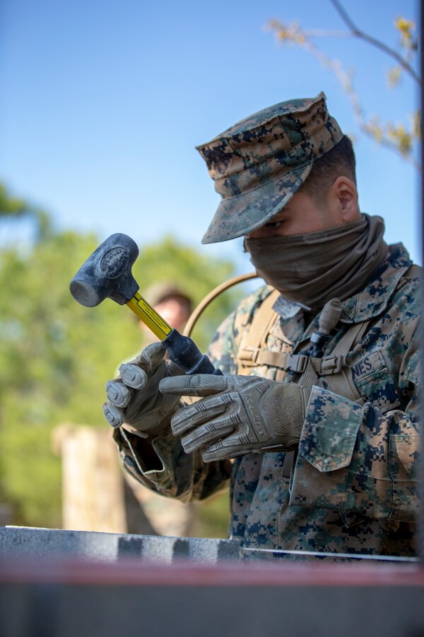Lance Cpl. Ian Garcia, a combat engineer with Special Purpose Marine Air-Ground Task Force - Southern Command, levels a cylinder block wall during a general exercise at Marine Corps Base Camp Lejeune, North Carolina, April 14, 2020. The combat engineers leveled the wall to help their construction project maintain its overall structural integrity. The GENEX includes training events such as engineering projects and evacuation control center training scenarios that will help build the SPMAGTF-SC for their final certification exercise. These training events also provide the Marines and Sailors with real-world scenarios to prepare them for their deployment to assist partner nation militaries in Latin America and the Caribbean. Garcia is a native of Wilsonville, Oregon. (U.S. Marine Corps photo by Cpl. Benjamin D. Larsen)