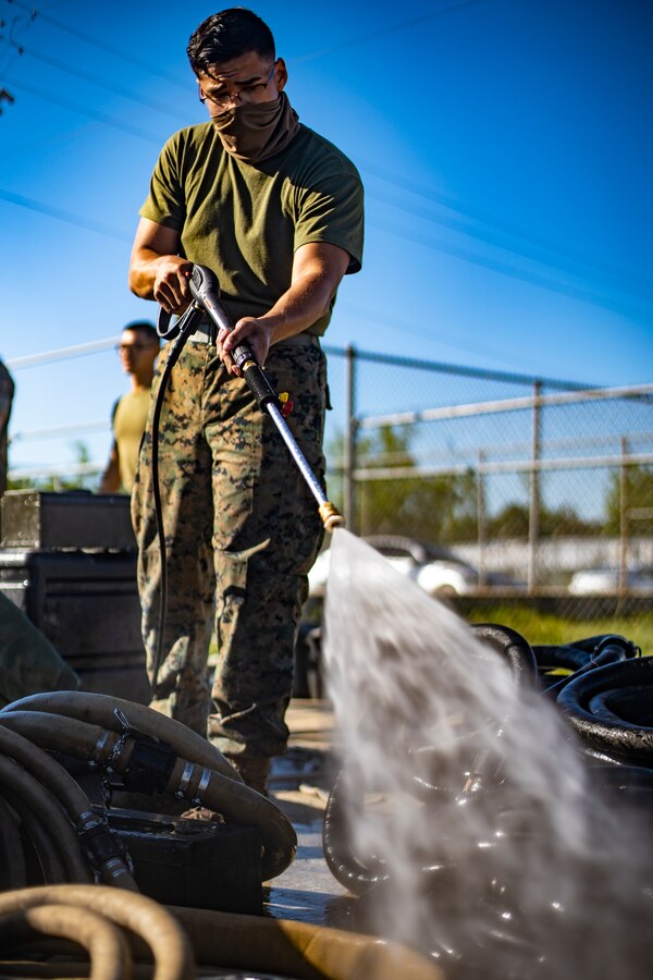 Lance Cpl. Manuel Flores, a refrigeration and air conditioning technician with Special Purpose Marine Air-Ground Task Force - Southern Command, operates a pressure washer during a general exercise at Camp Lejeune, North Carolina, April 14, 2020. The Marines removed dirt and debris from equipment to help minimize the risk of agricultural contamination before putting it into storage for future use. The GENEX includes training events such as engineering projects and evacuation control center training scenarios that will help build the SPMAGTF-SC for their final certification exercise. These training events also provide the Marines and Sailors with real-world scenarios to prepare them for their deployment to assist partner nation militaries in Latin America and the Caribbean. Flores is a native of Fort Worth, Texas. (U.S. Marine Corps photo by Sgt. Andy O. Martinez)