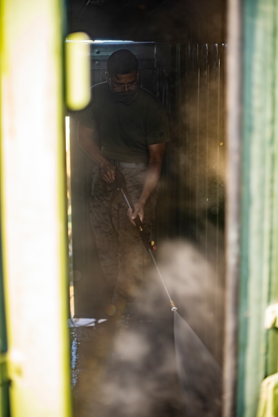 Lance Cpl. Manuel Flores, a refrigeration and air conditioning technician with Special Purpose Marine Air-Ground Task Force - Southern Command, removes dirt off hoses with a pressure washer during a general exercise at Camp Lejeune, North Carolina, April 14, 2020. The Marines removed dirt and debris from equipment to help minimize the risk of agricultural contamination before putting it into storage for future use. The GENEX includes training events such as engineering projects and evacuation control center training scenarios that will help build the SPMAGTF-SC for their final certification exercise. These training events also provide the Marines and Sailors with real-world scenarios to prepare them for their deployment to assist partner nation militaries in Latin America and the Caribbean. Flores is a native of Fort Worth, Texas. (U.S. Marine Corps photo by Sgt. Andy O. Martinez)