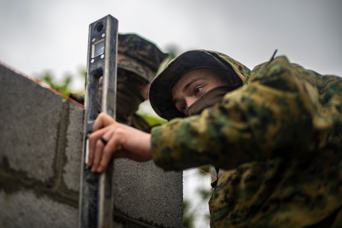 Lance Cpl. Tyler Alexander, a combat engineer with Special Purpose Marine Air-Ground Task Force - Southern Command, levels a concrete brick during a general exercise at Camp Lejeune, North Carolina, April 15, 2020. The GENEX includes training events such as engineering projects and evacuation control center training scenarios that will help build the SPMAGTF-SC for their final certification exercise. These training events also provide the Marines and Sailors with real-world scenarios to prepare them for their deployment to assist partner nation militaries in Latin America and the Caribbean. Alexander is a native of Scappoose, Oregon. (U.S. Marine Corps photo by Sgt. Andy O. Martinez)