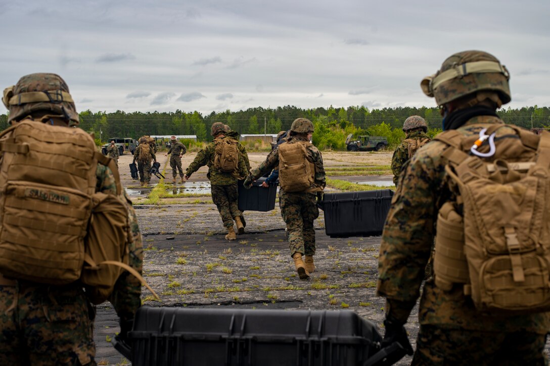 Marines and Sailors with Special Purpose Marine Air-Ground Task Force - Southern Command deboard a CH-53E Super Stallion helicopter with equipment needed for evacuation control center training during a general exercise at Camp Lejeune, North Carolina, April 15, 2020. The GENEX includes training events such as engineering projects and evacuation control center training scenarios that will help build the SPMAGTF-SC for their final certification exercise. These training events also provide the Marines and Sailors with real-world scenarios to prepare them for their deployment to assist partner nation militaries in Latin America and the Caribbean. (U.S. Marine Corps photo by Sgt. Andy O. Martinez)