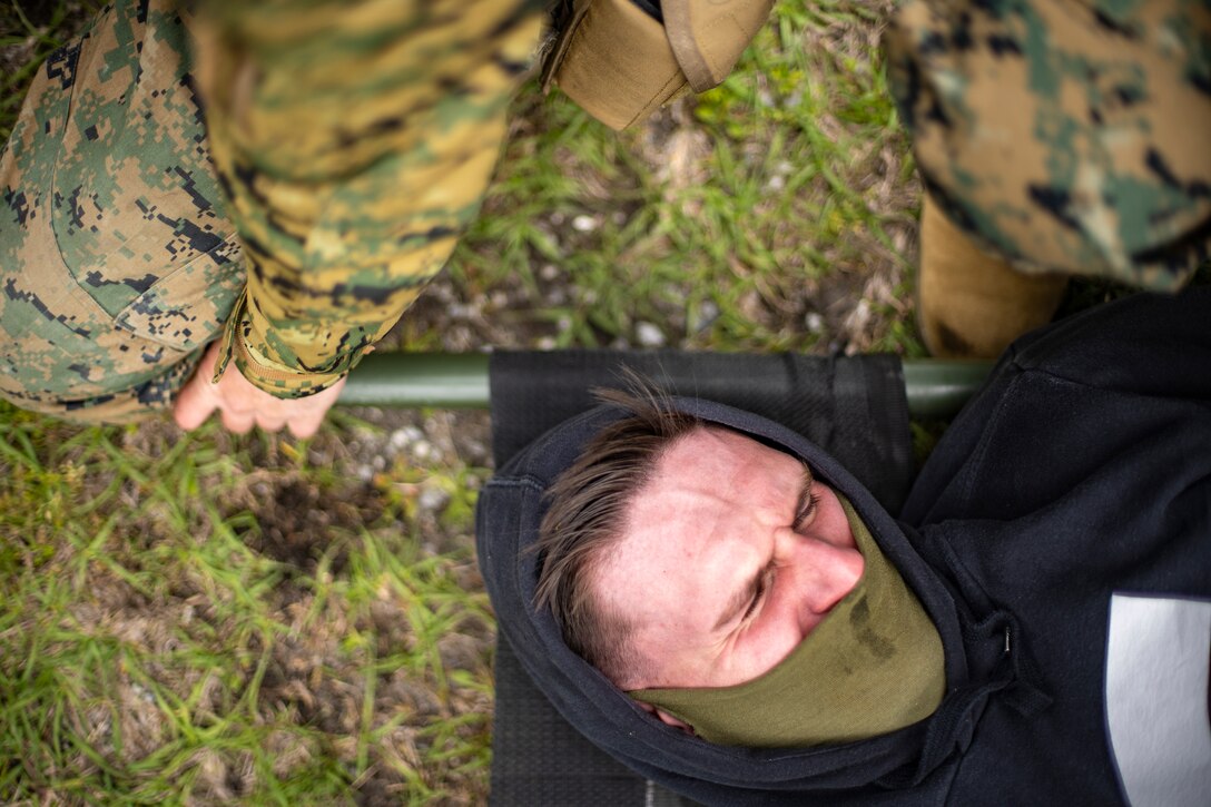 Cpl. Mathew Massam, a financial management resource analyst with Special Purpose Marine Air-Ground Task Force - Southern Command, role-plays as a casualty during a general exercise at Camp Lejeune, North Carolina, April 15, 2020. The GENEX includes training events such as engineering projects and evacuation control center training scenarios that will help build the SPMAGTF-SC for their final certification exercise. These training events also provide the Marines and Sailors with real-world scenarios to prepare them for their deployment to assist partner nation militaries in Latin America and the Caribbean. Massam is a native of Winter Haven, Florida. (U.S. Marine Corps photo by Sgt. Andy O. Martinez)