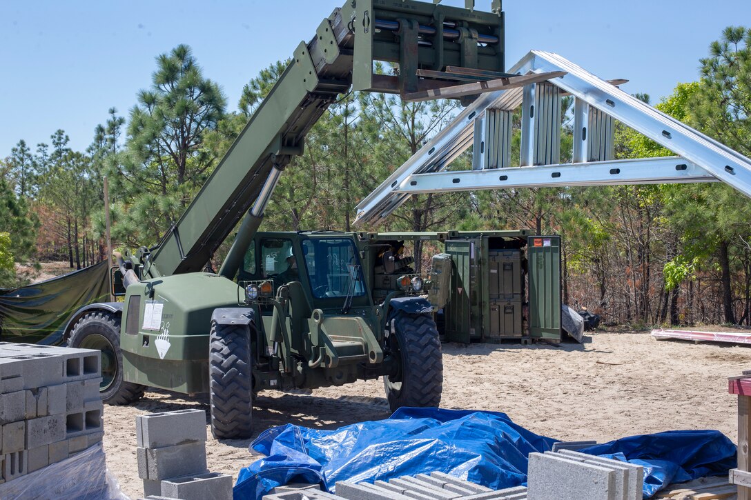 Lance Cpl. Oliver Cravens, a heavy equipment operator with Special Purpose Marine Air-Ground Task Force - Southern Command, delivers the prefabricated roof joints during a general exercise at Marine Corps Base Camp Lejeune, North Carolina, April 16, 2020. The GENEX includes training events such as engineering projects and evacuation control center training scenarios that will help build the SPMAGTF-SC for their final certification exercise. These training events also provide the Marines and Sailors with real-world scenarios to prepare them for their deployment to assist partner nation militaries in Latin America and the Caribbean. Cravens is a native of Portland, Oregon. (U.S. Marine Corps photo by Cpl. Benjamin D. Larsen)