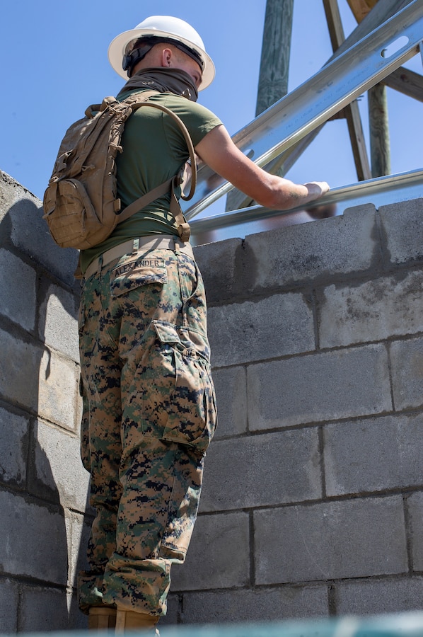 Lance Cpl. Tyler Alexander, a combat engineer with Special Purpose Marine Air-Ground Task Force - Southern Command, holds a roof joint in place during a general exercise at Marine Corps Base Camp Lejeune, North Carolina, April 16, 2020. Combat engineer Marines are increasing their construction skills in preparation for infrastructure improvement projects scheduled during their upcoming deployment to Latin America. The GENEX includes training events such as engineering projects and evacuation control center training scenarios that will help build the SPMAGTF-SC for their final certification exercise. These training events also provide the Marines and Sailors with real-world scenarios to prepare them for their deployment to assist partner nation militaries in Latin America and the Caribbean. Alexander is a native of Scappoose, Oregon. (U.S. Marine Corps photo by Cpl. Benjamin D. Larsen)