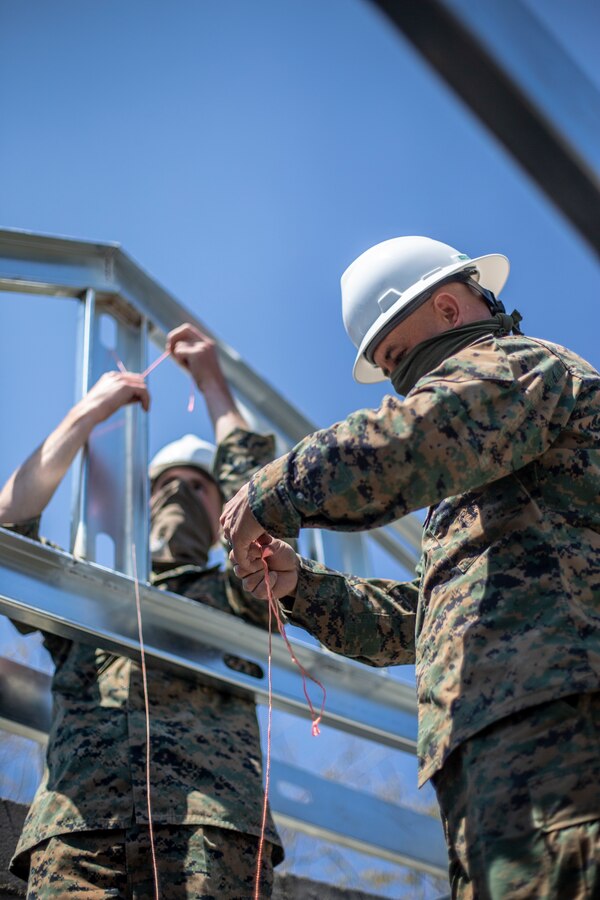 Lance Cpl. Vance Miller, left, and Gunnery Sgt. Michael Bowcutt, right, combat engineers with Special Purpose Marine Air-Ground Task Force - Southern Command, prepare a string line to gauge the level of the roof joints during the general exercise at Marine Corps Base Camp Lejeune, North Carolina, April 16, 2020. Combat engineer Marines are increasing their construction skills in preparation for infrastructure improvement projects scheduled during their upcoming deployment to Latin America. The GENEX includes training events such as engineering projects and evacuation control center training scenarios that will help build the SPMAGTF-SC for their final certification exercise. These training events also provide the Marines and Sailors with real-world scenarios to prepare them for their deployment to assist partner nation militaries in Latin America and the Caribbean. Miller is a native of Salem, Oregon. Bowcutt is a native of Oceanside, California. (U.S. Marine Corps photo by Cpl. Benjamin D. Larsen)