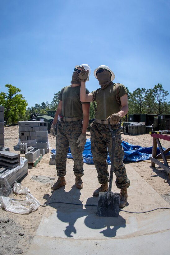 Cpl. Andrew McDonald, left, and Lance Cpl. Christopher Alvarez, right, combat engineers with Special Purpose Marine Air-Ground Task Force - Southern Command, evaluate a roof in construction during the general exercise at Marine Corps Base Camp Lejeune, North Carolina, April 16, 2020. The GENEX includes training events such as engineering projects and evacuation control center training scenarios that will help build the SPMAGTF-SC for their final certification exercise. These training events also provide the Marines and Sailors with real-world scenarios to prepare them for their deployment to assist partner nation militaries in Latin America and the Caribbean. McDonald is a native of Dallas, Oregon. Alvarez is a native of Portland, Oregon. (U.S. Marine Corps photo by Cpl. Benjamin D. Larsen)