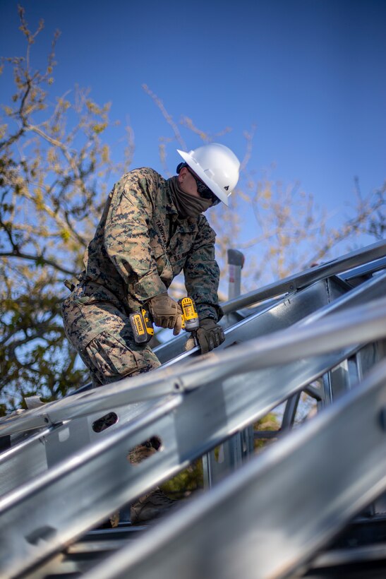 Cpl. Pavel Tarkovskiy, a technical engineer with Special Purpose Marine Air-Ground Task Force - Southern Command, constructs a roof during a general exercise at Marine Corps Base Camp Lejeune, North Carolina, April 17, 2020. The GENEX includes training events such as engineering projects and evacuation control center training scenarios that will help build the SPMAGTF-SC for their final certification exercise. These training events also provide the Marines and Sailors with real-world scenarios to prepare them for their deployment to assist partner nation militaries in Latin America and the Caribbean. Tarkovskiy is a native of Portland, Oregon. (U.S. Marine Corps photo by Cpl. Benjamin D. Larsen)