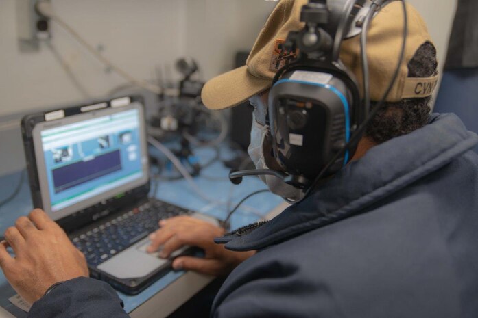 Information Systems Technician 1st Class James Davis, from Columbia, South Carolina, performs a test run of the Distance Communications Maintenance System (DCoMS) aboard the Navy's forward-deployed aircraft carrier, USS Ronald Reagan (CVN 76), the flagship of Carrier Strike Group 5, while the ship was underway conducting routine operations.