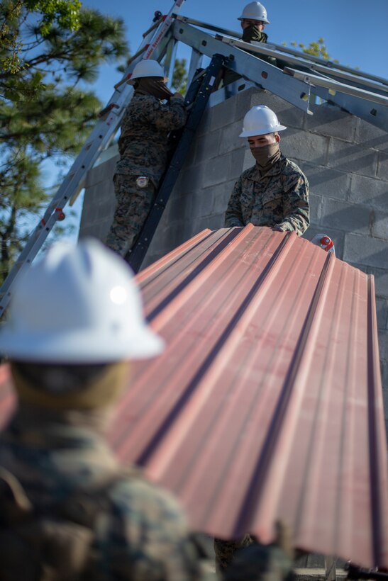 Engineers with Special Purpose Marine Air-Ground Task Force - Southern Command construct a roof during the general exercise at Marine Corps Base Camp Lejeune, North Carolina, April 17, 2020. The GENEX includes training events such as engineering projects and evacuation control center training scenarios that will help build the SPMAGTF-SC for their final certification exercise. These training events also provide the Marines and Sailors with real-world scenarios to prepare them for their deployment to assist partner nation militaries in Latin America and the Caribbean. (U.S. Marine Corps photo by Cpl. Benjamin D. Larsen)