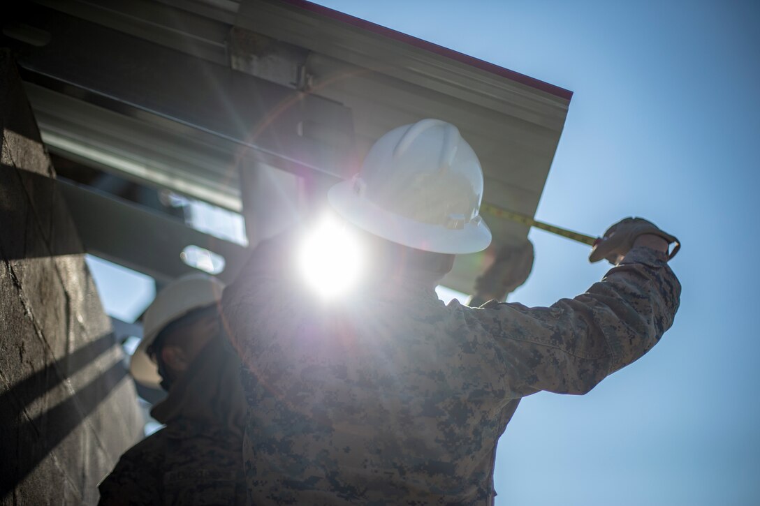 Lance Cpl. Ian Garcia, a combat engineer with Special Purpose Marine Air-Ground Task Force - Southern Command, measures the overhang of a roof panel during a general exercise at Marine Corps Base Camp Lejeune, North Carolina, April 17, 2020. The GENEX includes training events such as engineering projects and evacuation control center training scenarios that will help build the SPMAGTF-SC for their final certification exercise. These training events also provide the Marines and Sailors with real-world scenarios to prepare them for their deployment to assist partner nation militaries in Latin America and the Caribbean. Garcia is a native of Wilsonville, Oregon. (U.S. Marine Corps photo by Cpl. Benjamin D. Larsen)