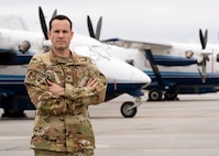 Commander stands in front of aircraft.