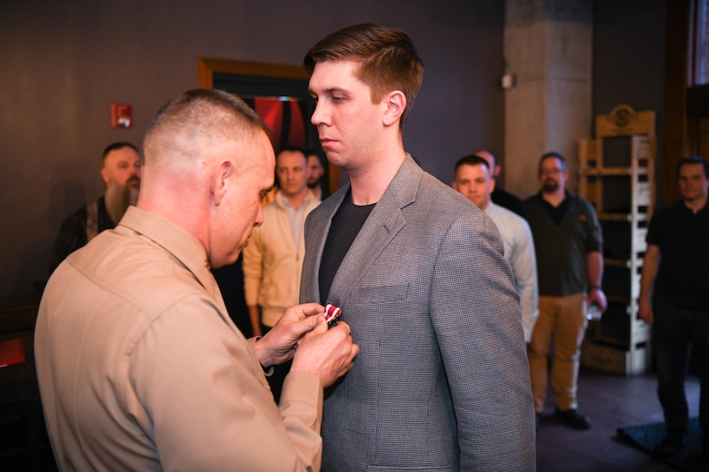 Marine Corps veteran Staff Sergeant Nathanial Vanderhayden, formerly a Marine Corps cyber operator, takes a group photo with old friends, after receiving the Meritorious Service Medal at a dinner February 18th.