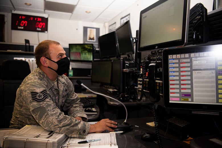 Tech. Sgt Gregory Forte, 30th Space Wing senior emergency actions controller, works on a checklist with Airman Basic Julia Hitter, 30th Space Wing junior emergency actions controller May 18, 2020, at Vandenberg Air Force Base, Calif. Due to COVID-19, the 30th SW Command Post team broke into three shifts, with 2 controllers per shift. To ensure each shift and controller team had the same information, the team developed a shift change over, continuity binder and a shift checklist. (U.S. Air Force photo by Senior Airman Hanah Abercrombie)
