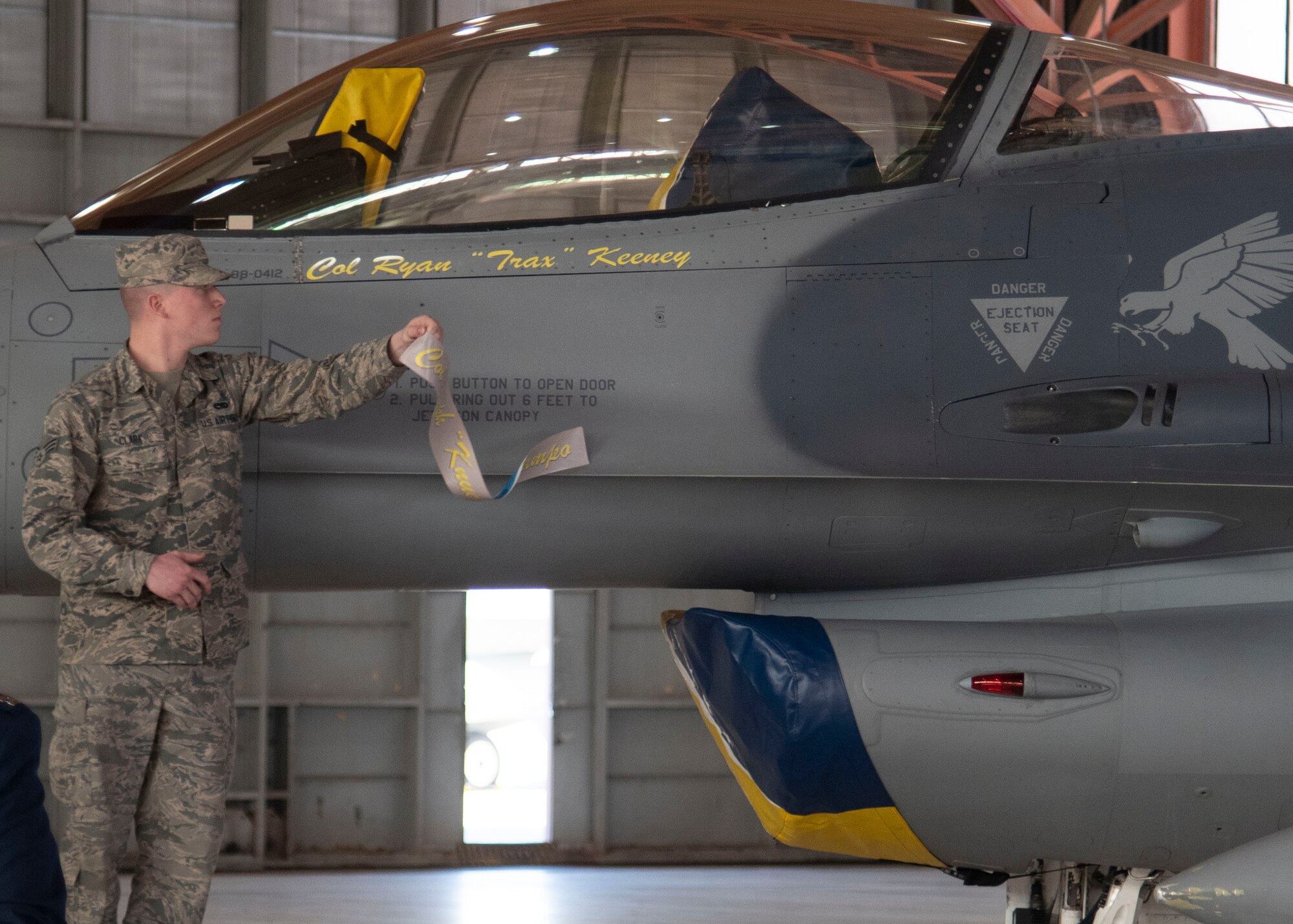 Senior Airman Connor Clark, 849th Aircraft Maintenance Squadron assistant dedicated crew chief, unveils Col. Ryan Keeney’s, 49th Wing commander, name on the 49th WG flagship, May 21, 2020, on Holloman Air Force Base, N.M. Traditionally, the 49th WG flagship bears the name of the current Wing Commander. (U.S. Air Force photo by Tech. Sgt. BreeAnn Sachs)
