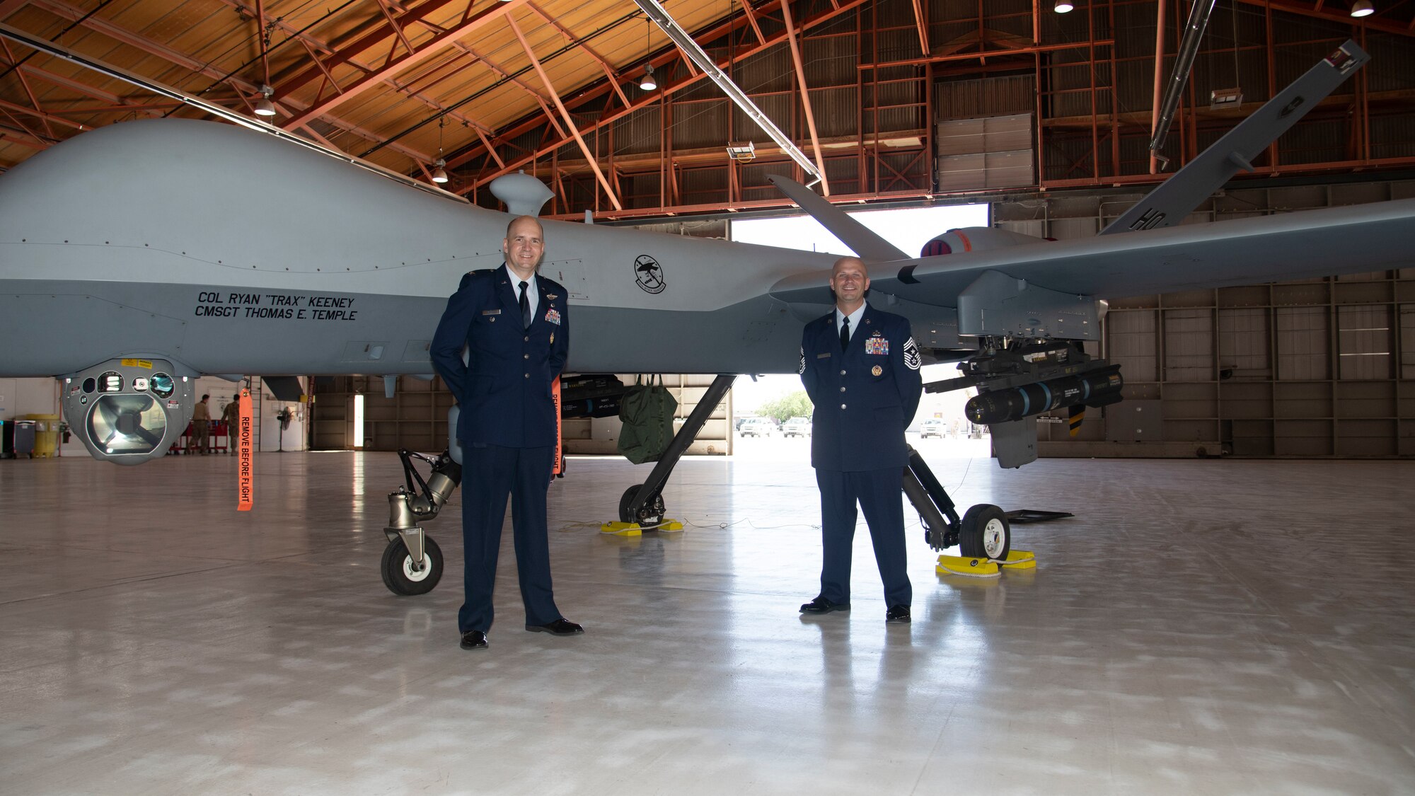 Col. Ryan Keeney, 49th Wing commander and Chief Master Sgt. Thomas Temple, 49th WG command chief, pose in front of an MQ-9 Reaper, May 21, 2020, on Holloman Air Force Base, N.M. Keeney assumed command of the 49th WG during a formal ceremony. (U.S. Air Force photo by Tech. Sgt. BreeAnn Sachs)