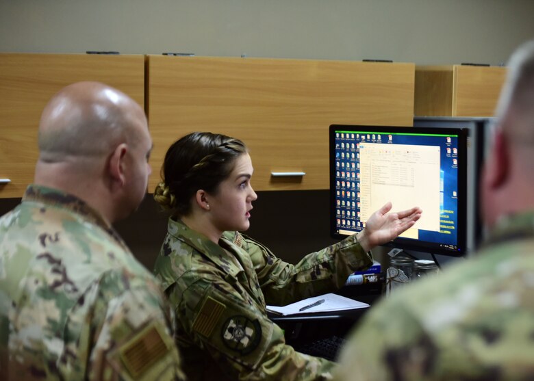 Staff Sgt. Amy Sievers, 386th Expeditionary Contracting Squadron contracting officer, center, provides a walkthrough of construction contracts to Chief Master Sgt. Jason Colon, 386th Air Expeditionary Wing command chief, left, and Col. Rod Simpson, 386th AEW commander, right, during a wing immersion program at Ali Al Salem Air Base, Kuwait, March 19, 2020. The weekly immersion program, “In Your Boots,” allows wing leadership to see first-hand how squadrons support the mission. (U.S. Air Force photo by Senior Airman Isaiah J. Soliz)