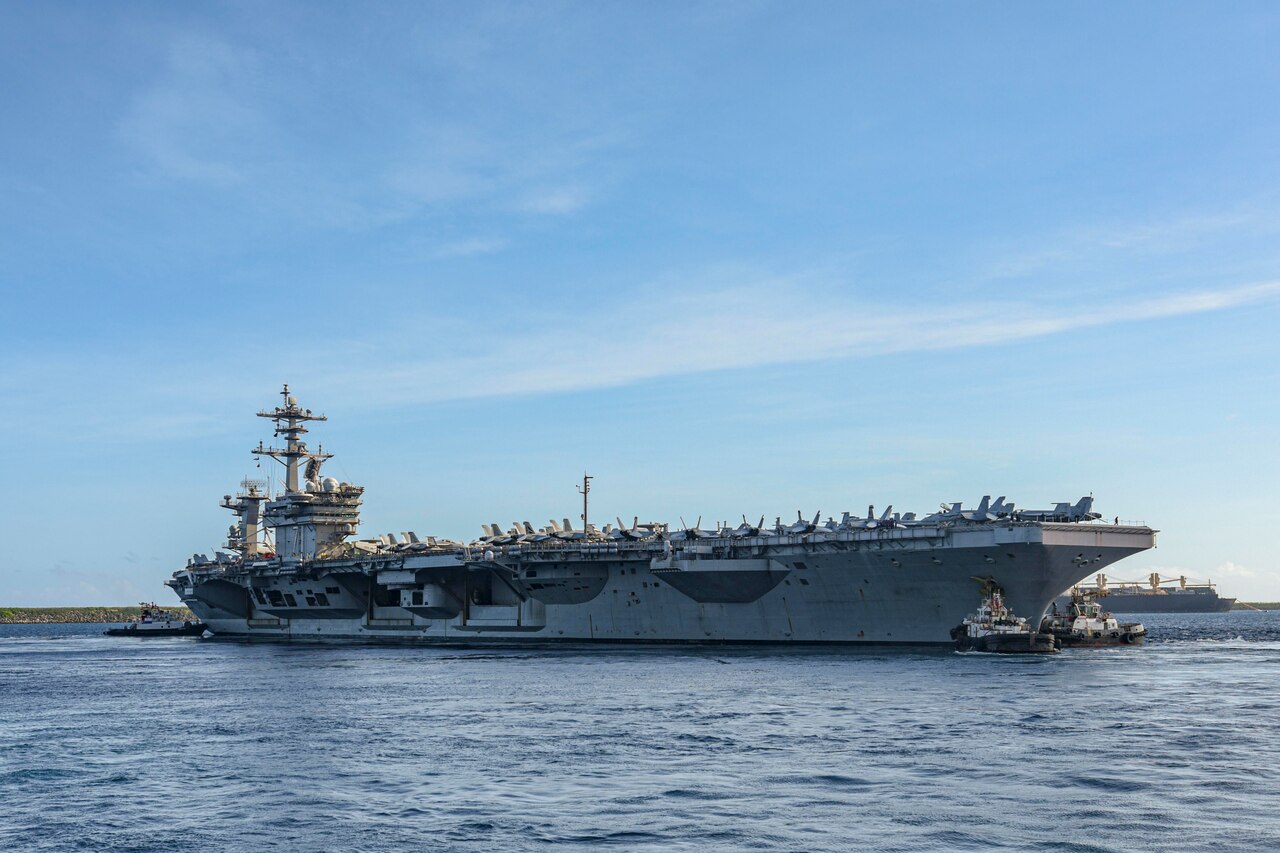 A large warship moves across the water.