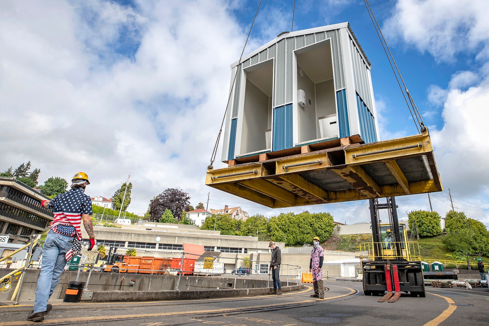 Shop 740 crew members lift a new hand washing station into Dry Dock 4 May 19, 2020 at Puget Sound Naval Shipyard & Intermediate Maintenance Facility in Bremerton, Washington.