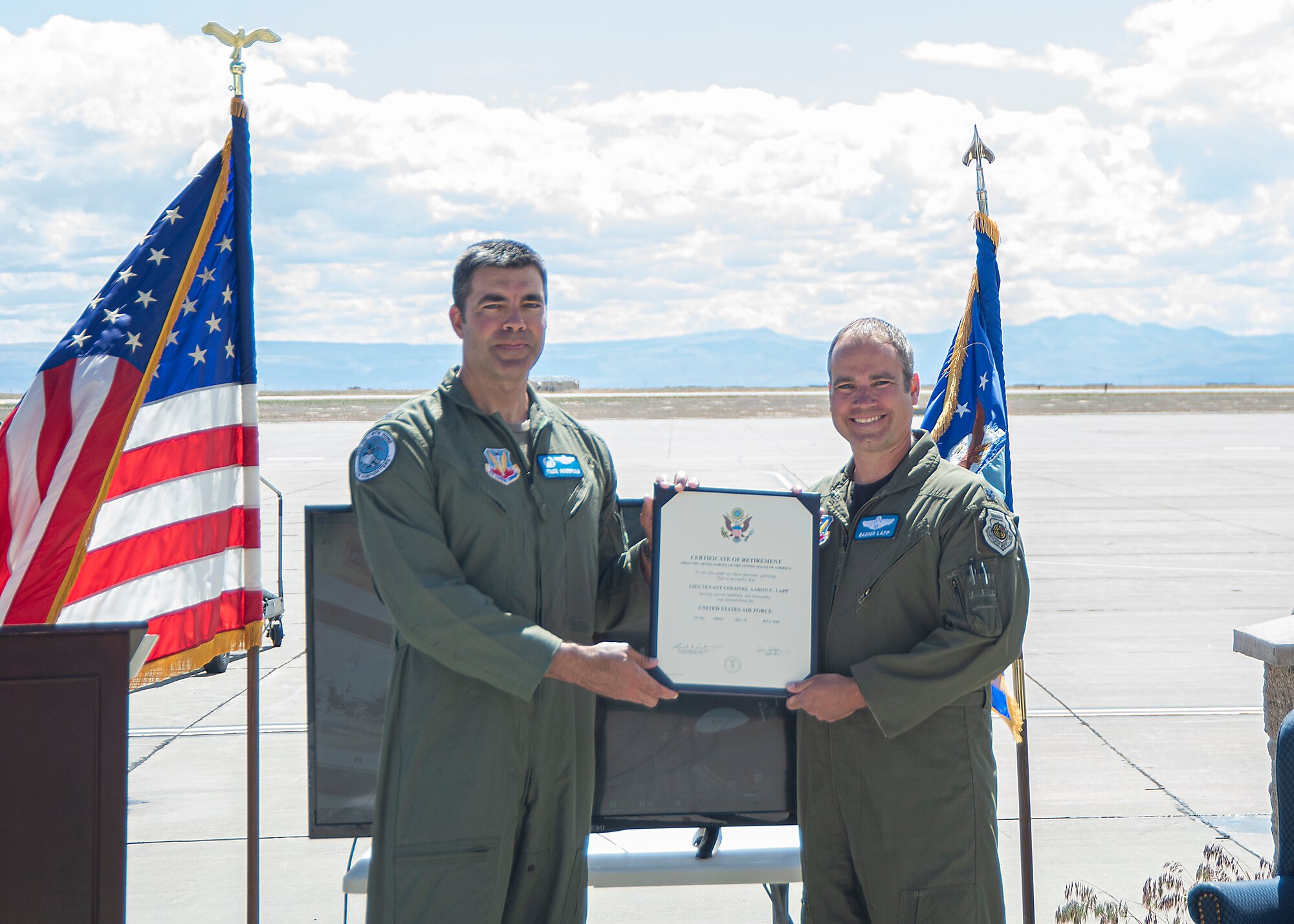 U.S. Air Force Col. Richard A. Goodman, 366th Fighter Wing commander, presents the certificate of retirement to Lt. Col. Aaron C. “Badger” Lapp, 366th Fighter Wing director of operations and plans, May 15, 2020, on Mountain Home Air Force Base, Idaho. Lapp has served the Air Force for 20 years and one month and has completed 1,850 military missions. (U.S. Air Force photo by Airman 1st Class Akeem K. Campbell)