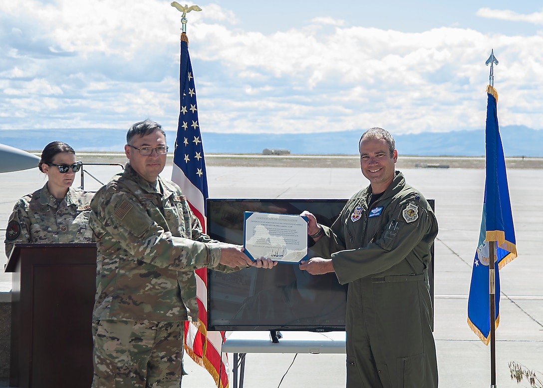 U.S. Air Force Senior Master Sgt. David Schummer, 366th Fighter Wing superintendent of operations and plans, presents Lt. Col. Aaron C. “Badger” Lapp, 366th Fighter Wing director of operations and plans, the certificate of appreciation, May 15, 2020, on Mountain Home Air Force Base, Idaho. Lapp has been involved in significant deployments such as Operation INHERENT RESOLVE and Operation DELIBERATE RESOLVE. (U.S. Air Force photo by Airman 1st Class Akeem K. Campbell)
