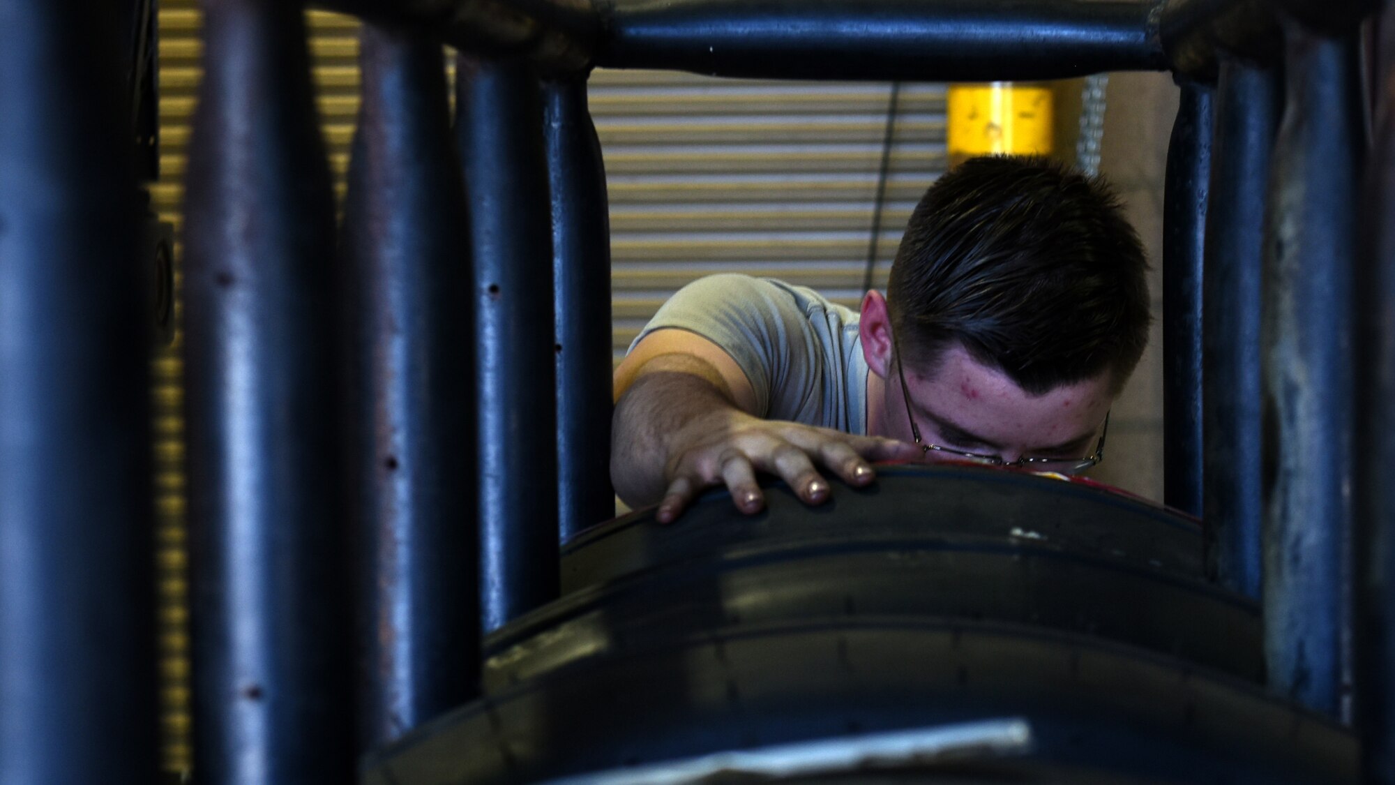 A photo of an Airman inspecting a tire