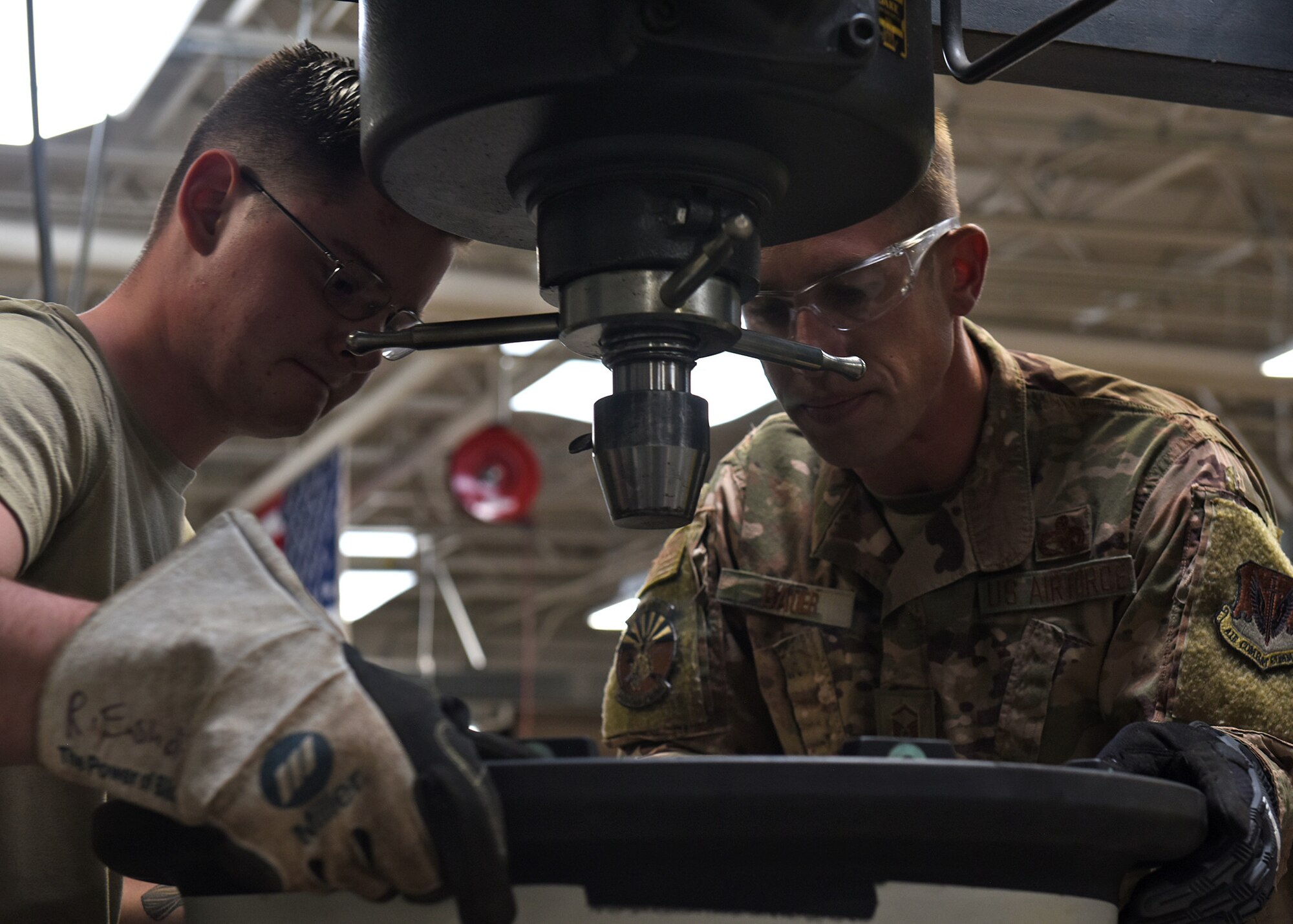 A photo of two Airmen working working with tools.