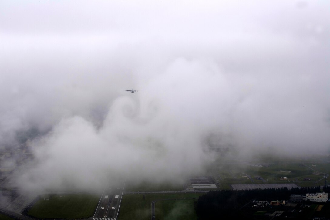 A C-130J Super Hercules, assigned to the 36th Airlift Squadron, flys through the clouds above the Yokota Air Base, Japan, flightline during the formation flight portion of the Samurai Surge training exercise, May 21, 2020.