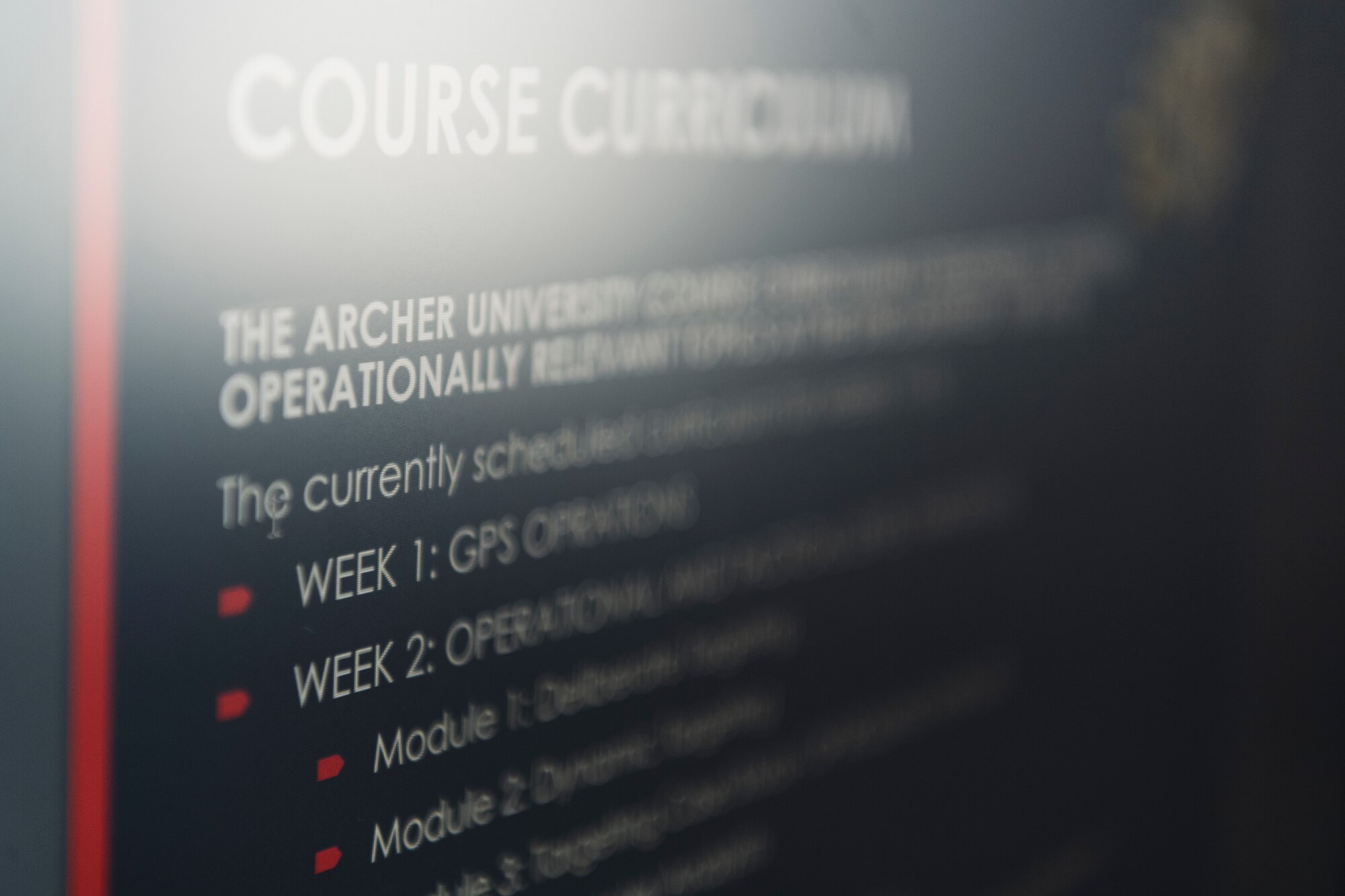 White text is on a screen detailing the syllabus and course curriculum of the Archer University program.