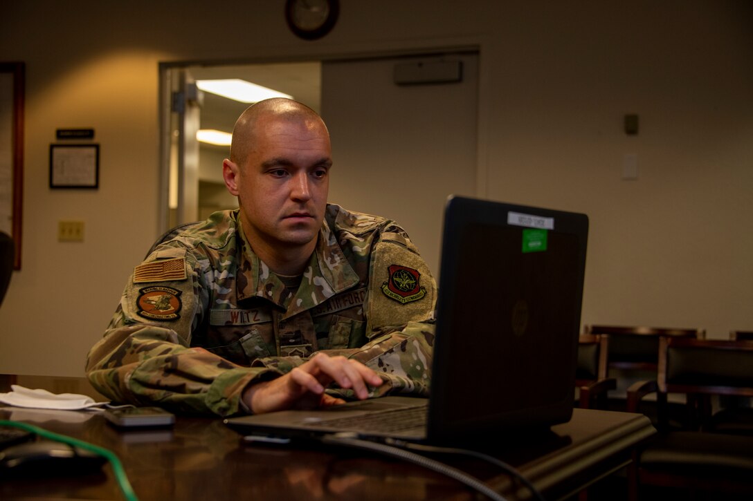 U.S. Air Force Master Sgt. Eric Wiltz, 60th Contracting Squadron contracting officer, sets up a computer for a presentation May 20, 2020, during a commercial solutions opening event at Travis Air Force Base, California. The event provided five companies an opportunity to present innovative solutions to enhance the mission at Travis AFB. (U.S. Air Force photo by Tech. Sgt. James Hodgman)