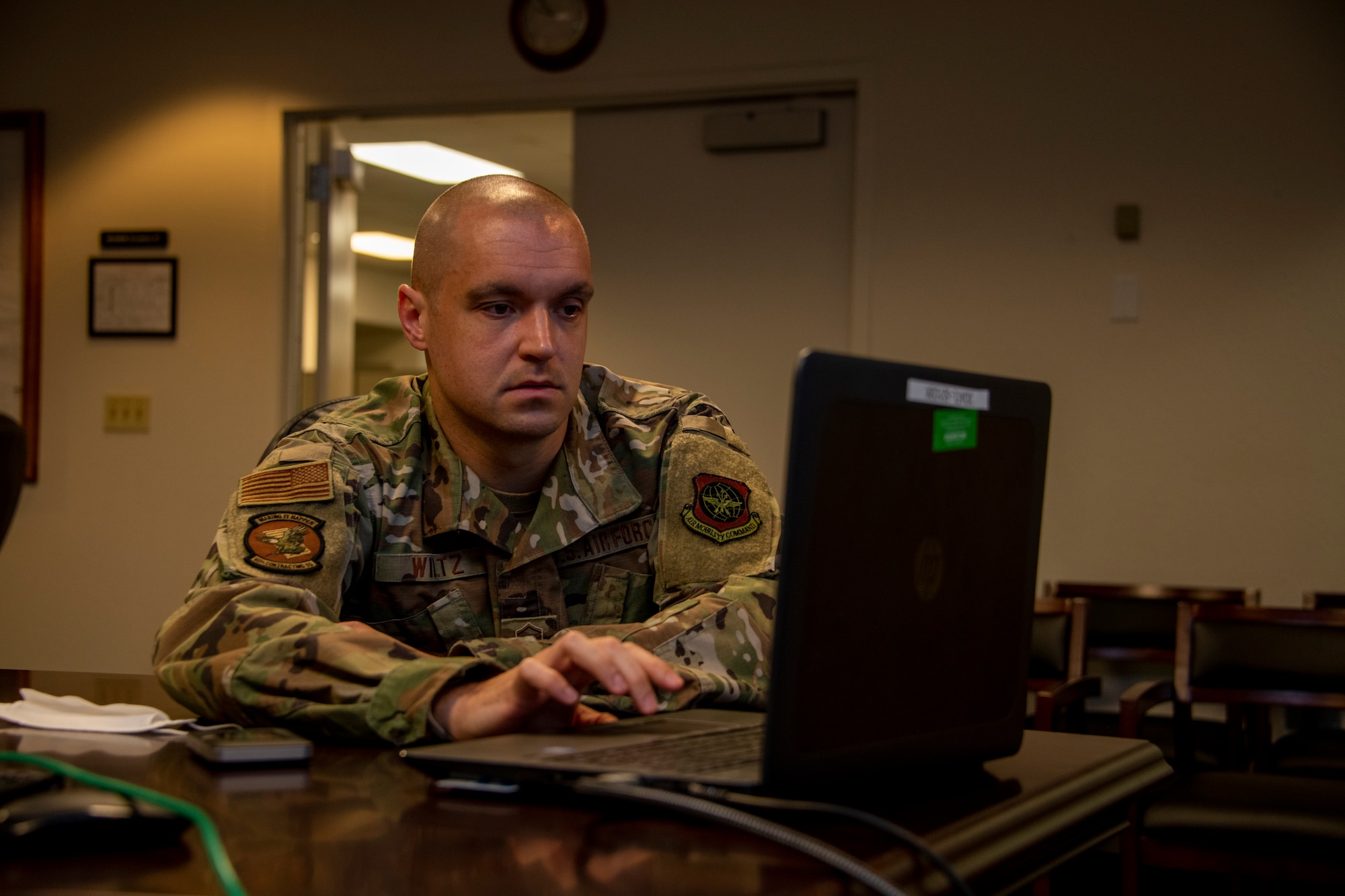 U.S. Air Force Master Sgt. Eric Wiltz, 60th Contracting Squadron contracting officer, sets up a computer for a presentation May 20, 2020, during a commercial solutions opening event at Travis Air Force Base, California. The event provided five companies an opportunity to present innovative solutions to enhance the mission at Travis AFB. (U.S. Air Force photo by Tech. Sgt. James Hodgman)