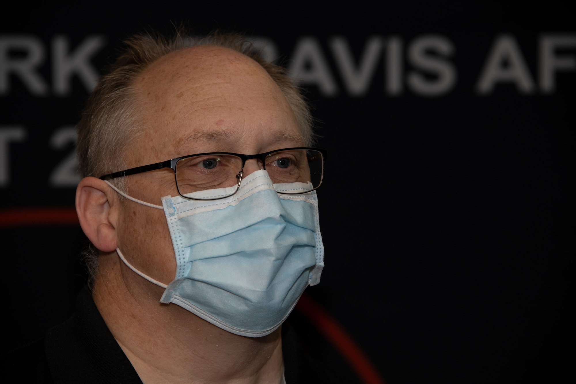 John Dickerson, 60th Air Mobility Wing innovation officer, wears a mask as he listens to a presentation May 20, 2020, during a commercial solutions offering event at Travis Air Force Base, California. The event, which featured 40 participants from 20 organizations, provided companies an opportunity to present innovative solutions to enhance the mission at Travis AFB. (U.S. Air Force photo by Tech. Sgt. James Hodgman)