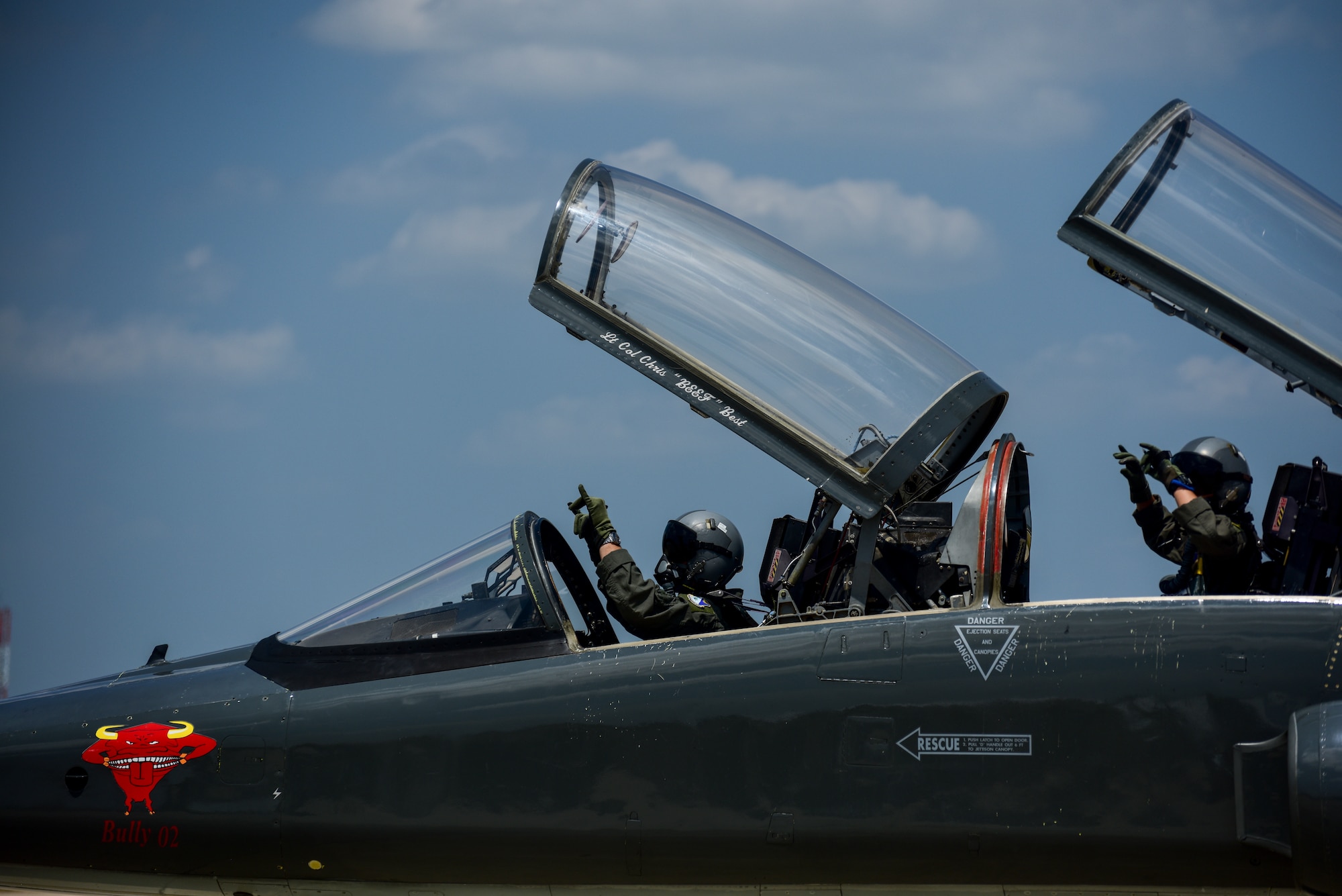 Two instructor pilots of Laughlin Air Force base sport the "hook 'em horns" to symbolize their squadron mascot--the 87th Flying Training Squadron's red bull-- as they depart Laughlin Air Force Base, Texas, to fly in a dissimilar formation of aircraft, over Del Rio and Eagle Pass, May 21, 2020. The flyover consisted of the T-6A Texan II, T-1A Jayhawk and the T-38 Talon and honored the men and women on the front lines of the fight against COVID-19 during the Defense Department’s #AmericaStrong salute. (U.S. Air Force photo by Senior Airman Anne McCready)