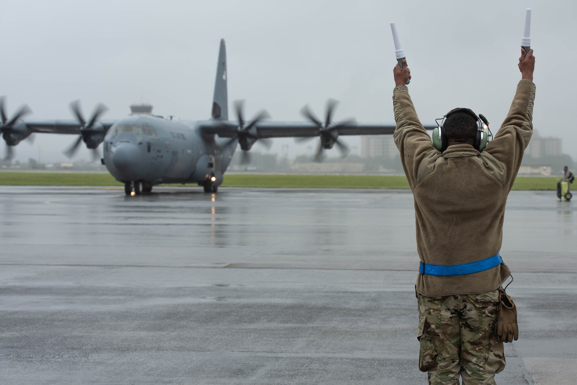 A crew chief, assigned to the 374th Aircraft Maintenance Squadron, marshals a C-130J Super Hercules during the 374th Airlift Wing’s Samurai Surge training exercise, May 21, 2020, at Yokota Air Base, Japan.