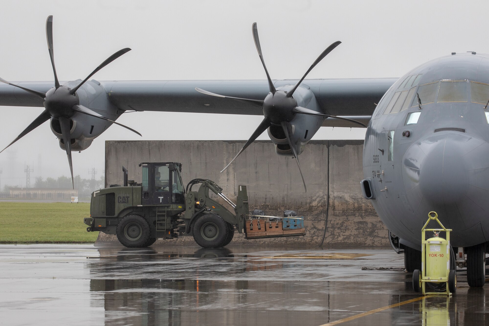 An Airman with the 374th Logistics Readiness Squadron combat mobility flight loads low-cost, low-altitude bundles with a forklift into a C-130J Super Hercules at Yokota Air Base, Japan, May 21, 2020, during the Samurai Surge training exercise.