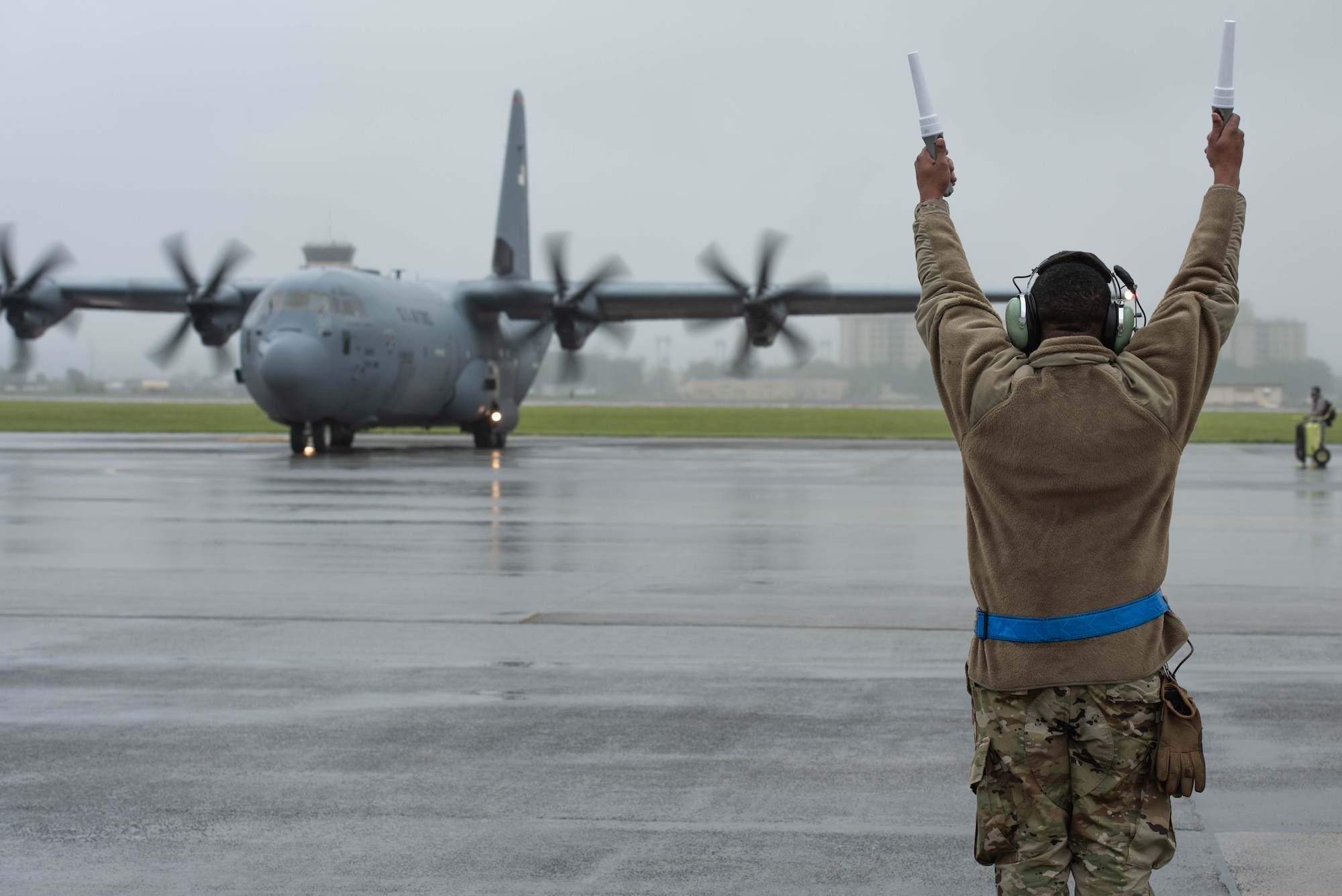 A crew chief, assigned to the 374th Aircraft Maintenance Squadron, marshals a C-130J Super Hercules during the 374th Airlift Wing’s Samurai Surge training exercise, May 21, 2020, at Yokota Air Base, Japan.