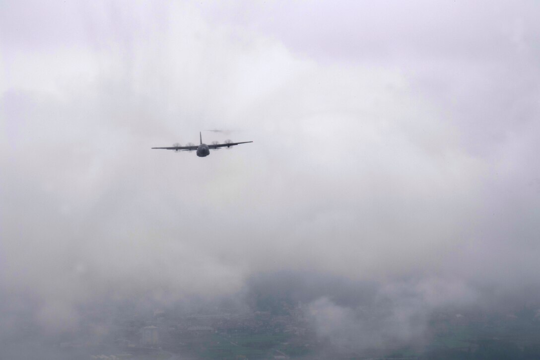 A C-130J Super Hercules, assigned to the 36th Airlift Squadron, flys through the clouds above the Yokota Air Base, Japan, flightline during the formation flight portion of the Samurai Surge training exercise, May 21, 2020.