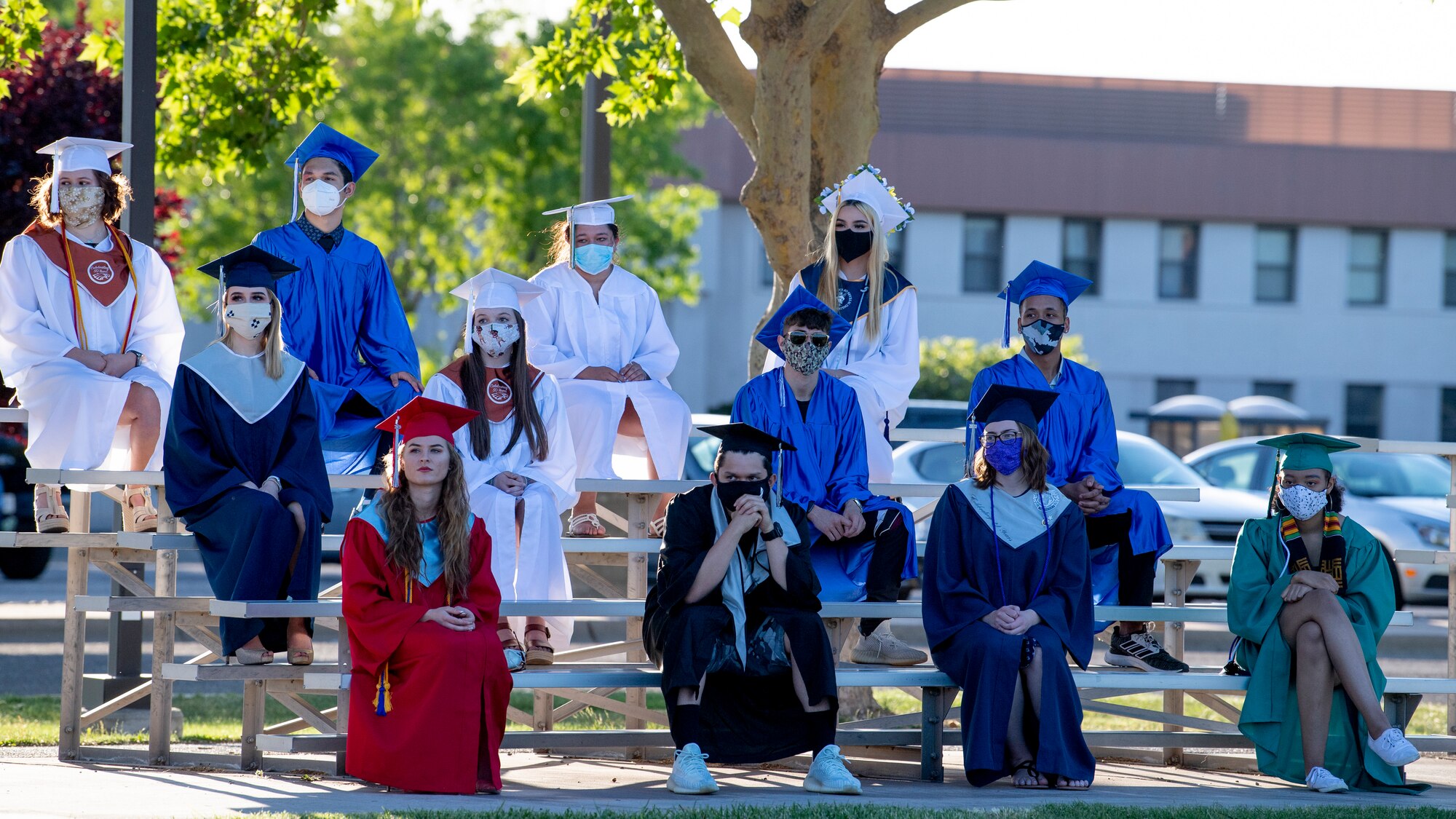 Graduates wait on the bleachers.