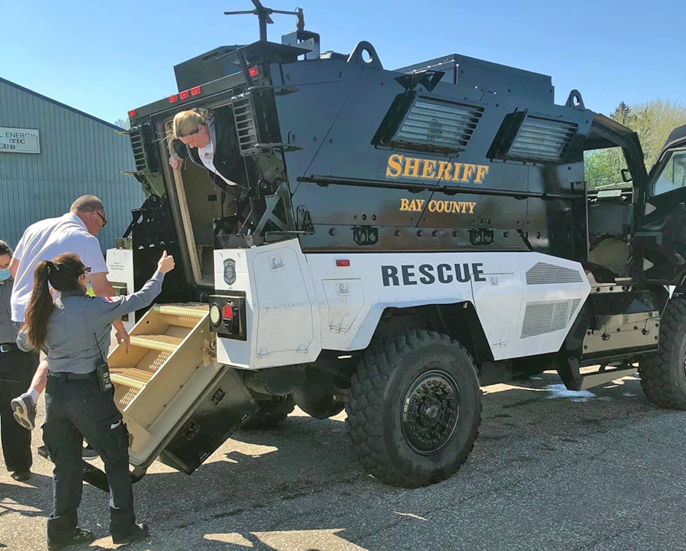 Deputies help residents exit an armored vehicle.