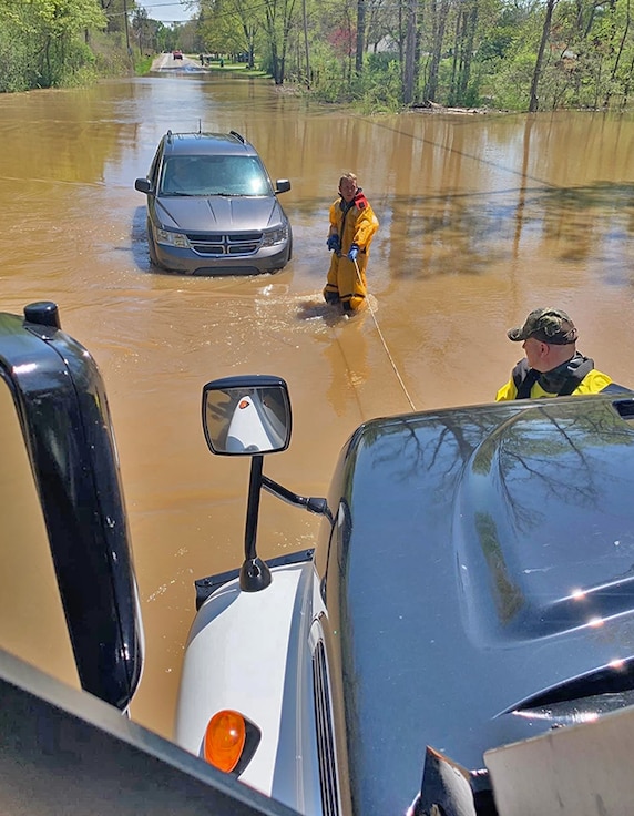 An MRAP prepares to pull a passenger vehicle from high water.