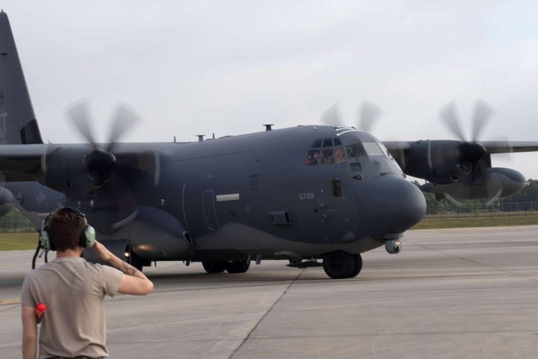 A photo of an Airmen saluting a departing aircraft