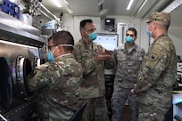 NEW YORK (May 20, 2020) Army Maj. Gaetano Casarella, assigned to the 24th Weapons of Mass Destruction Civil Support Team, speaks with the Commander of Task Force Northeast, Army Maj. Gen. William “Bill” Hall, about the COVID-19 testing process inside the mobile testing unit at the Javits Center in New York City, May 20, 2020.