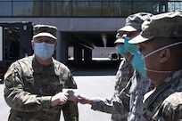NEW YORK (May 20, 2020) The Commander of Task Force Northeast, Army Maj. Gen. William “Bill” Hall, awards Air Force Tech Sgt. Jonathan Roldan, assigned to the 24th Weapons of Mass Destruction Civil Support Teams, during a coin presentation ceremony outside of the Javits Center in New York City, May 20, 2020.