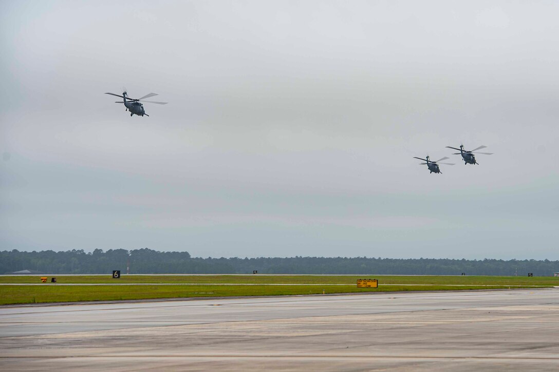Photo of three HH-60G Pave Hawks assigned to the 41st Rescue Squadron taking off.