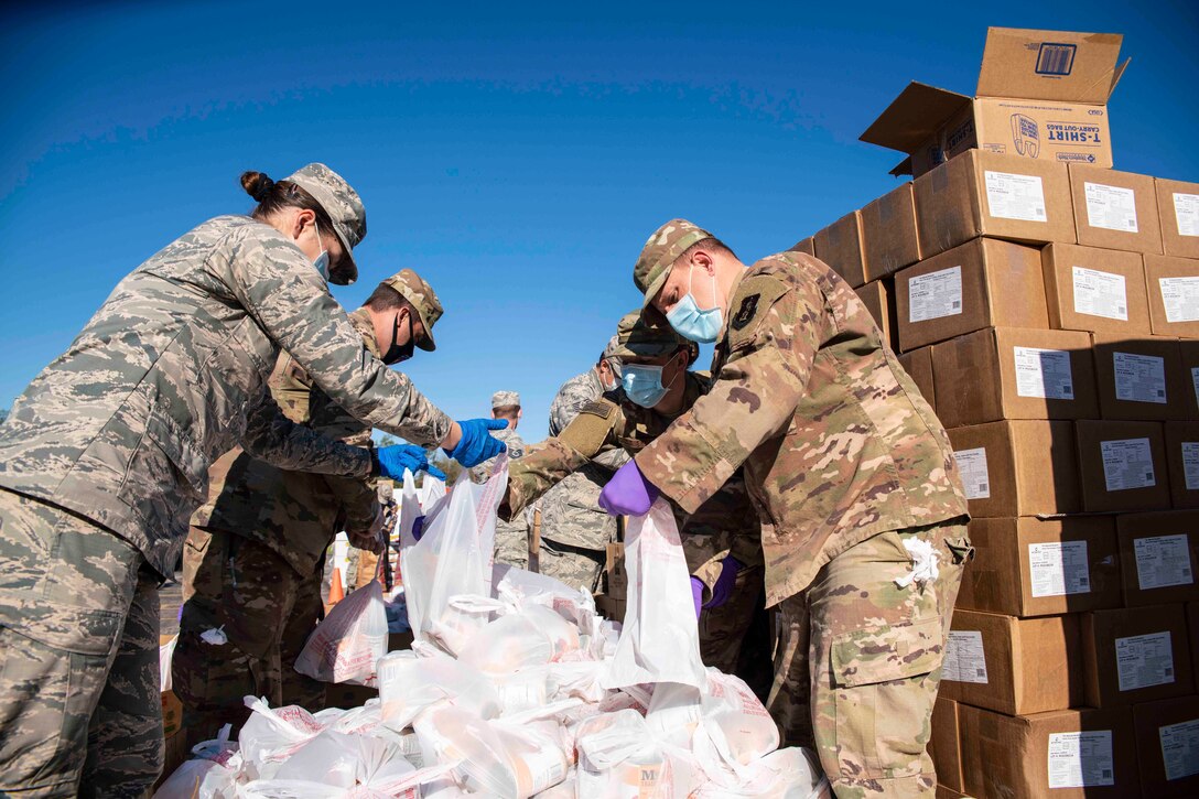 A group of airmen hold plastic bags.