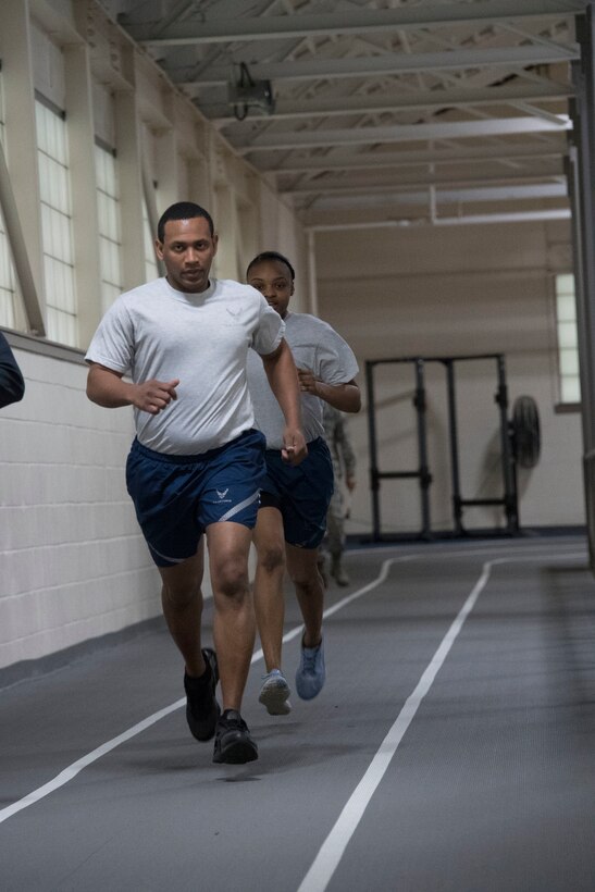 Photo of Airmen running on an indoor track