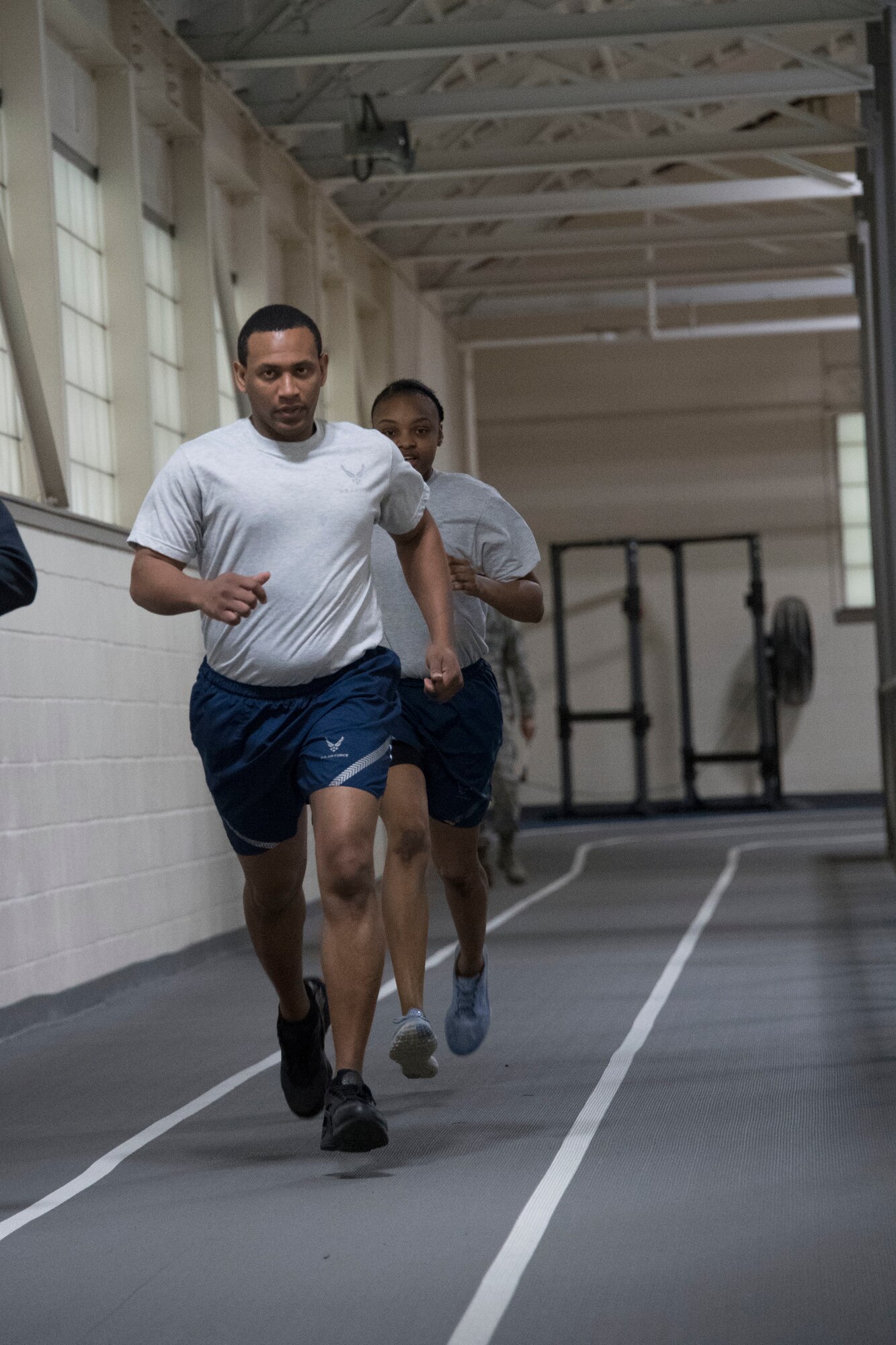 Photo of Airmen running on an indoor track