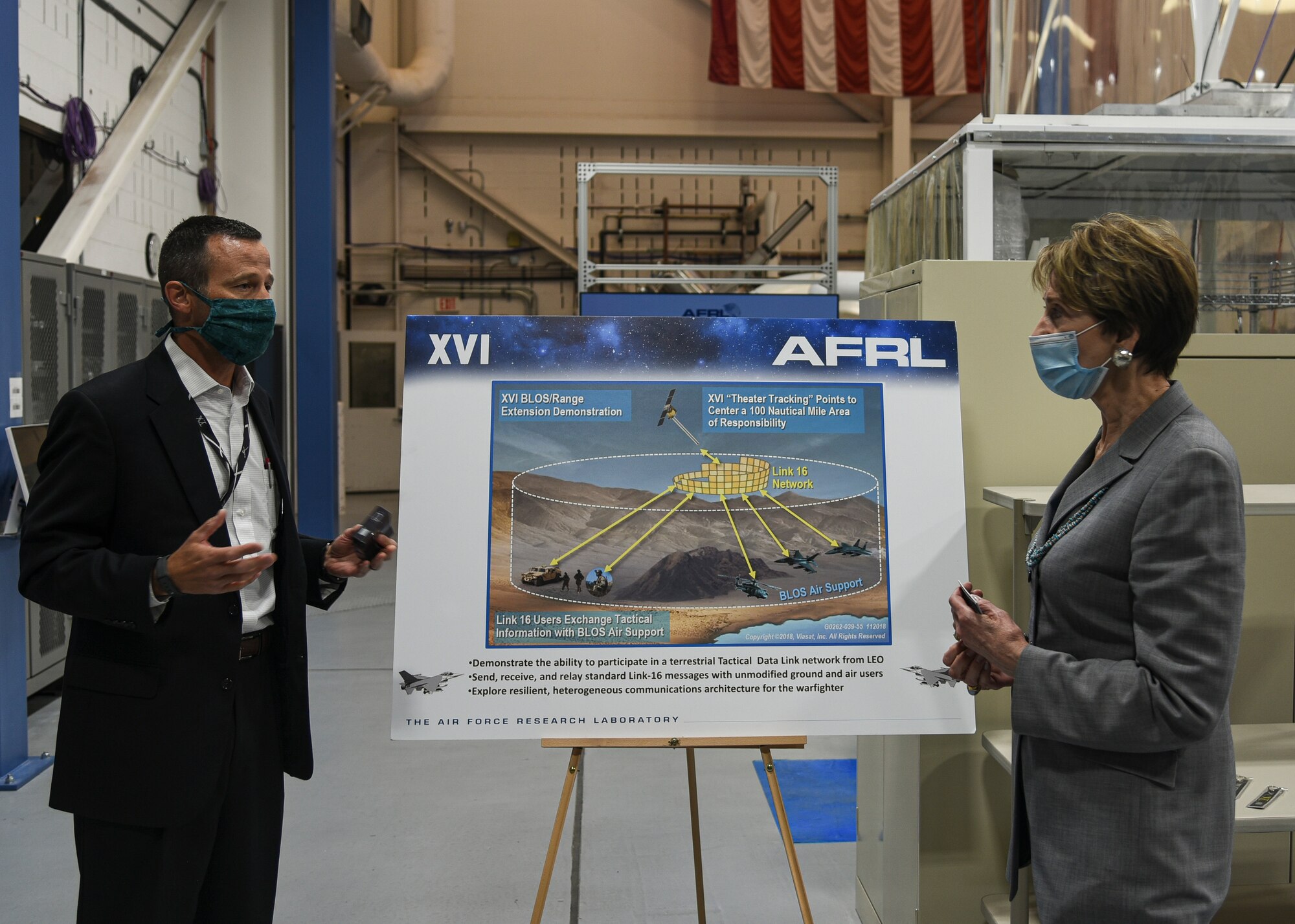 A person receiving a brief on AFRL small satellites