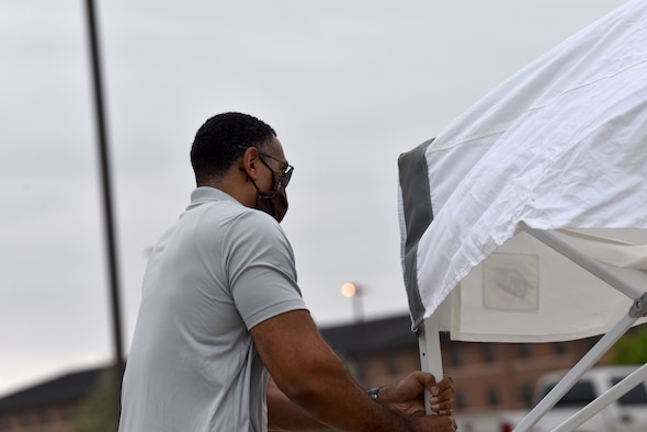 U.S. Air Force Master Sgt. Aaron Myers, first sergeant, helps assemble a canopy before the Memorial Day BBQ at the Crossroads on Goodfellow Air Force Base, Texas, May 23, 2020. The first sergeant council and Goodfellow Chapel teamed up to host a BBQ for the students confined to base during COVID-19. (U.S. Air Force photo by Senior Airman Seraiah Wolf)