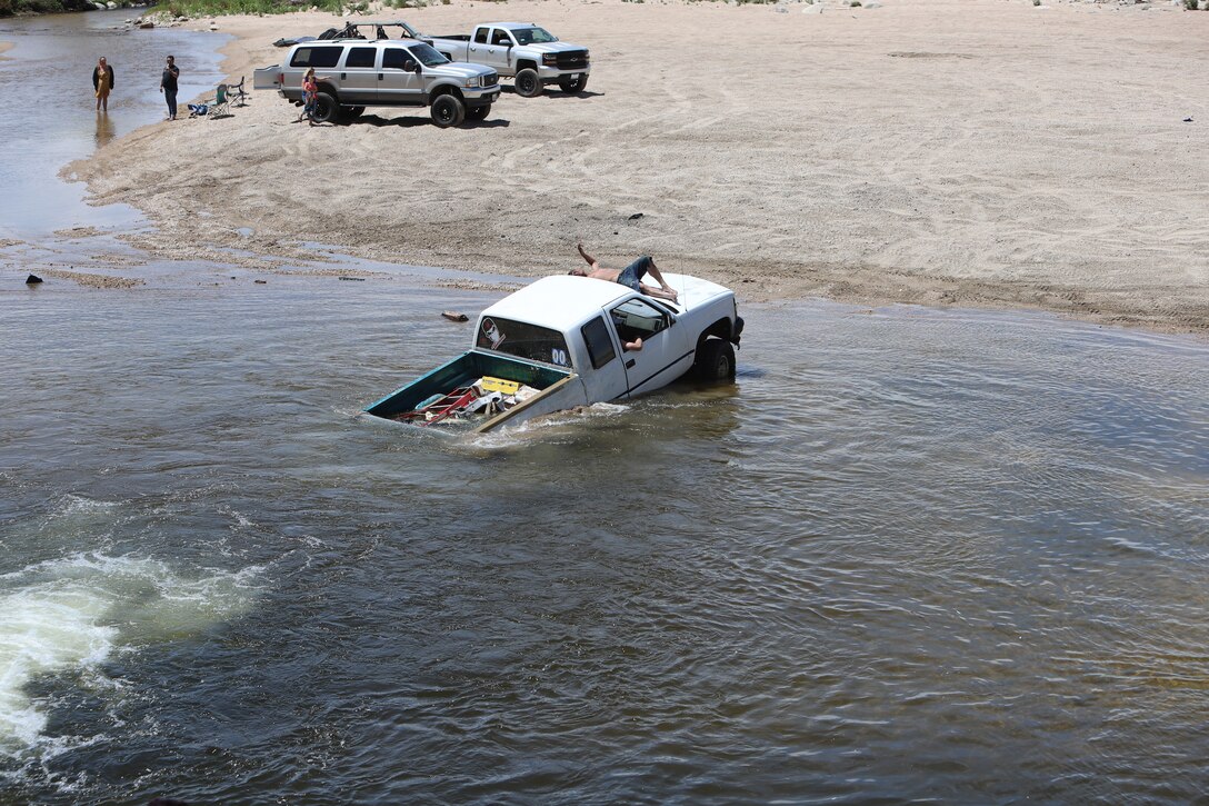 Driver of this vehicle awaits help from other drivers after becoming submerged in the Mojave River Dam's outlet May 17.