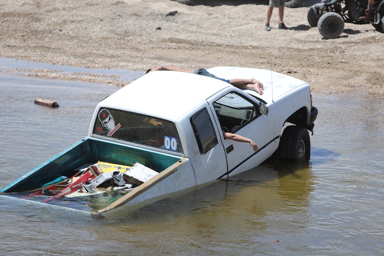 Driver of this vehicle awaits help from other drivers to pull their vehicle from the Mojave River Dam's water outlet May 17.